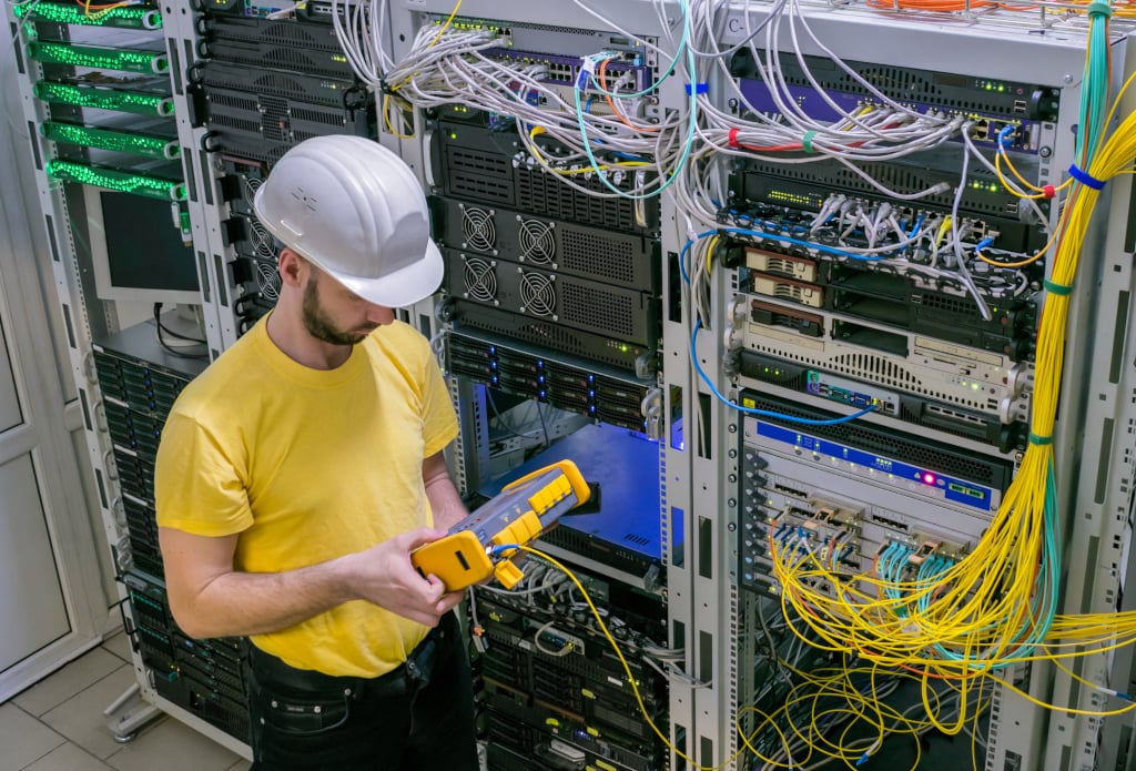 Fiber Characterization Engineer using an OTDR in a data center